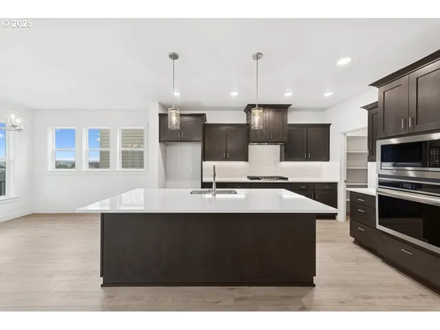a kitchen with kitchen island stainless steel appliances a sink counter space and cabinets