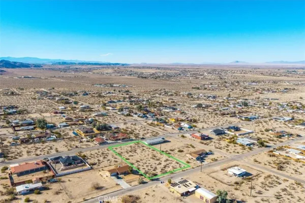 an aerial view of residential building and tree in the background