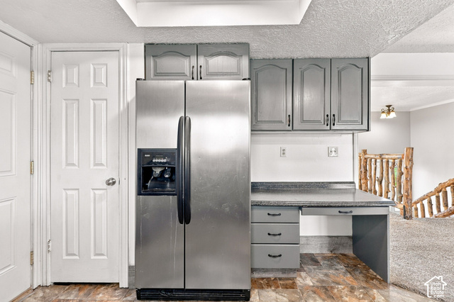 224 Canal Bank Road Garland, UT 84312 - Photo 11 of 21 Stainless steel refrigerator, gray cabinetry, built-in desk, wood-finish flooring, and natural wood staircase railing