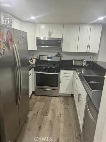 a kitchen with stainless steel appliances a stove a sink and a refrigerator