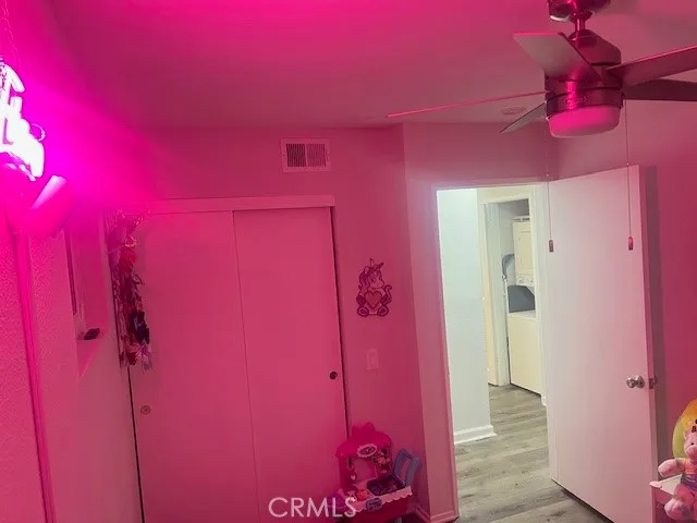 a view of a room with a red door and a chandelier fan