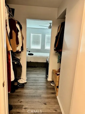 a view of walk in closet with clothes and shoes