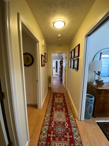 a view of a hallway with furniture and floor to ceiling window