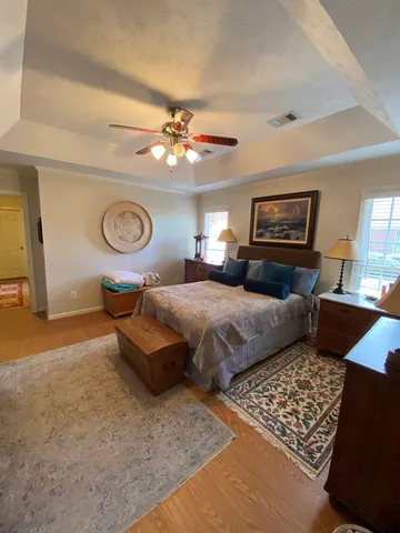 a bedroom with a bed ceiling fan and a window