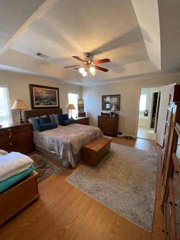 a spacious bedroom with a bed a couch and a chandelier