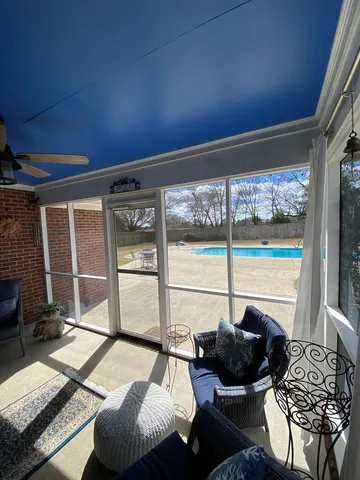 a living room with furniture and a floor to ceiling window