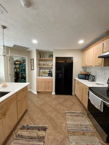 a large kitchen with a stove a refrigerator and a sink
