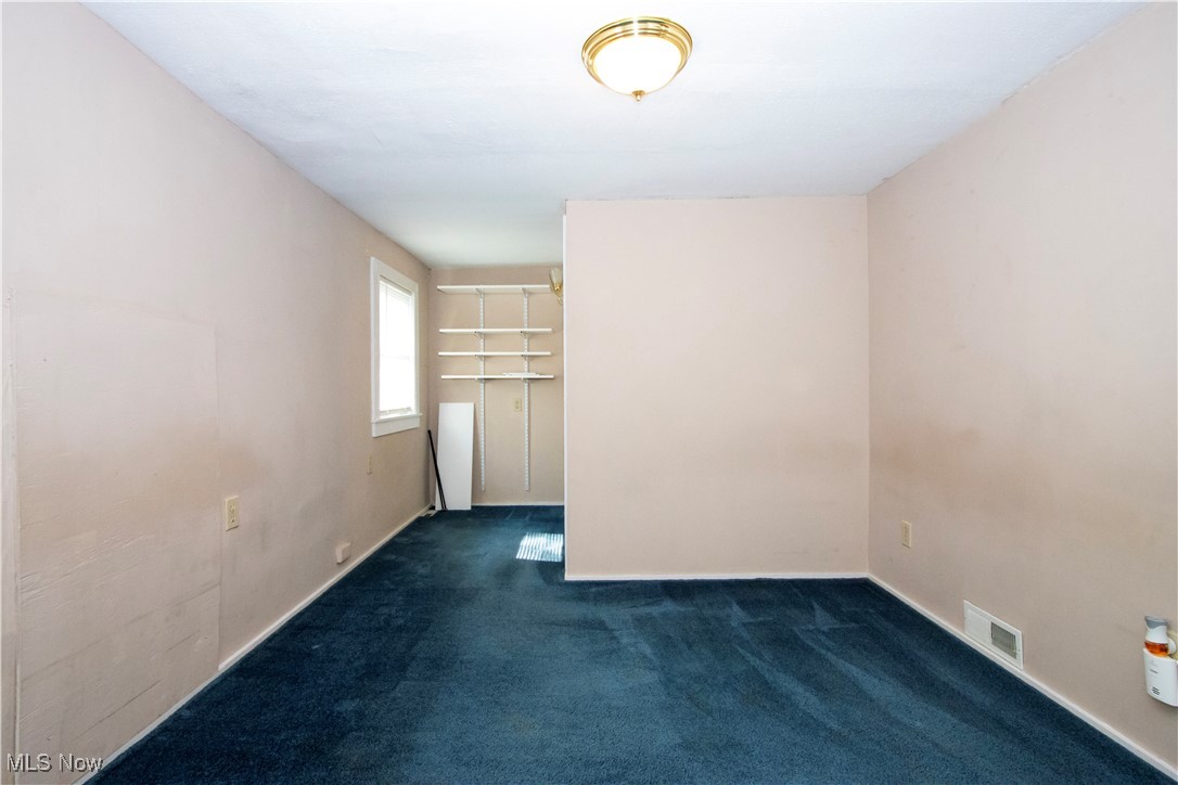 7210 Cleveland Road Wooster, OH 44691 - Photo 13 of 22 Empty room featuring dark colored carpet and baseboards