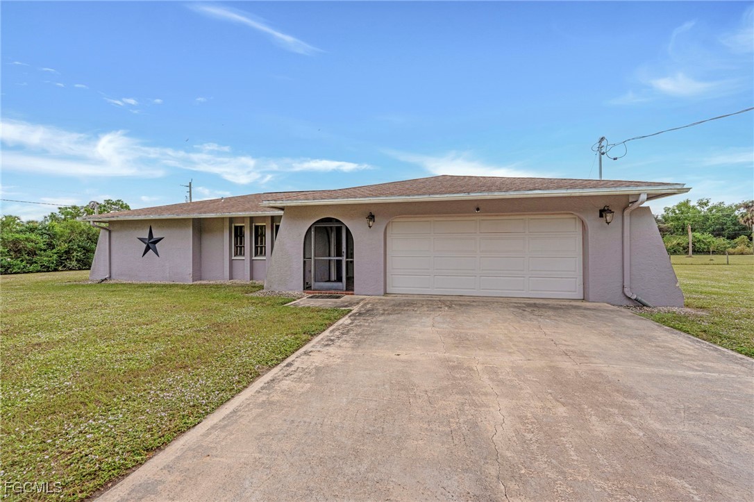 14501 Old Olga Road Fort Myers, FL 33905 - Photo 2 of 42 a front view of house with yard and garage