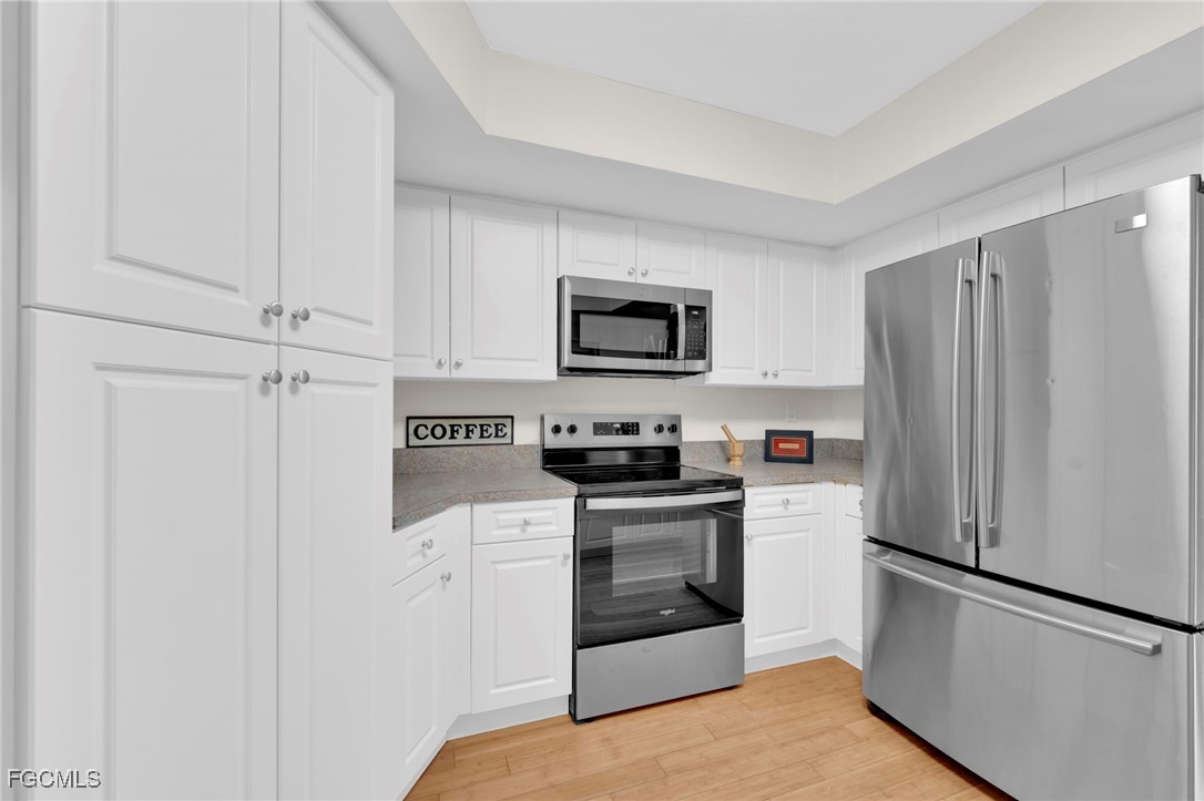 14501 Old Olga Road Fort Myers, FL 33905 - Photo 30 of 42 a kitchen with stainless steel appliances a refrigerator stove and white cabinets