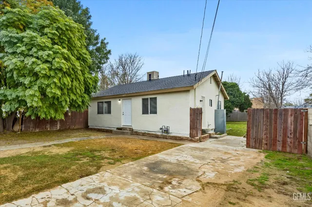 a view of a house with backyard and tree