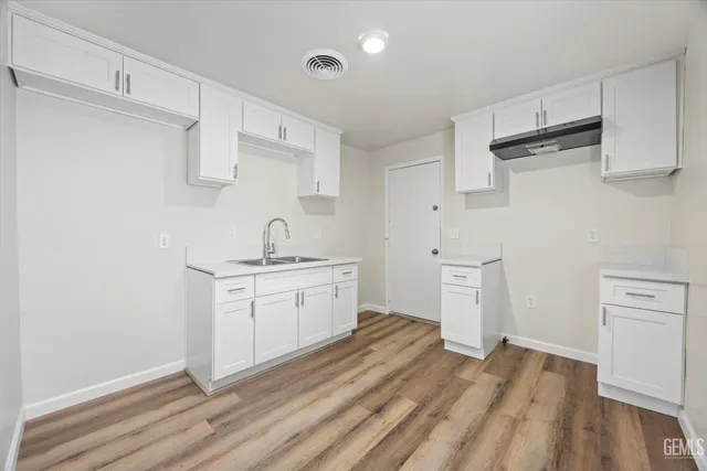 a kitchen with sink cabinets and wooden floor