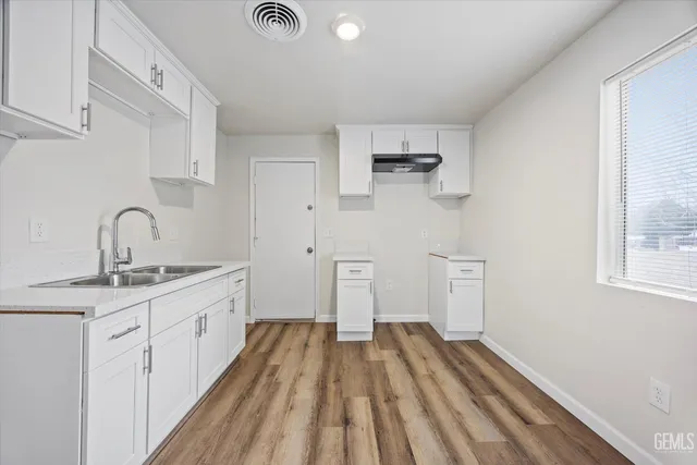 a kitchen with cabinets a sink and appliances