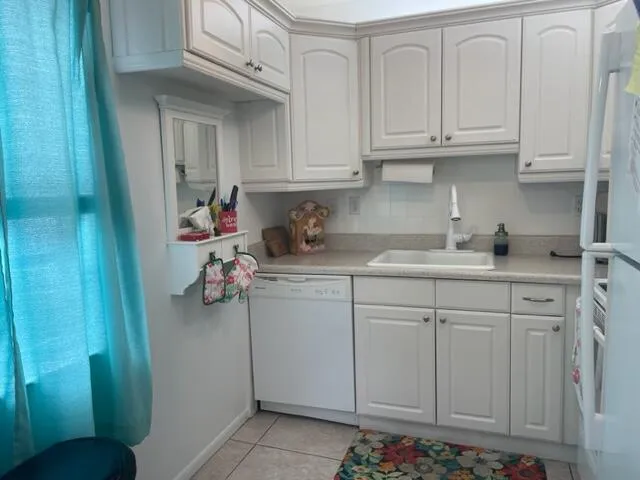 a kitchen with white cabinets and sink