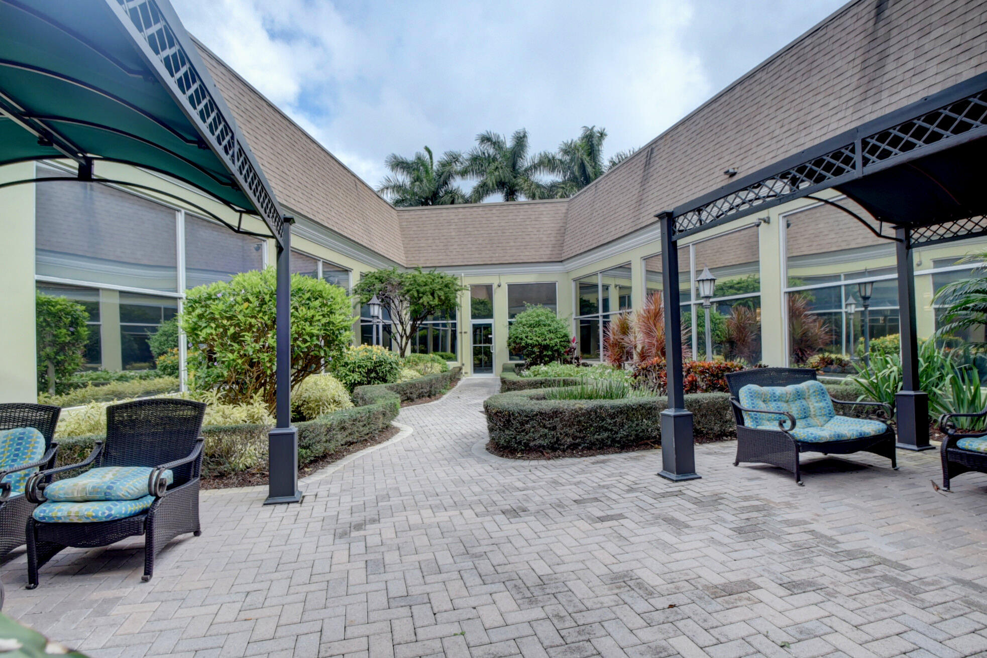 137 Flanders C Delray Beach, FL 33484 - Photo 52 of 55 a view of a patio with couches table and chairs and potted plants