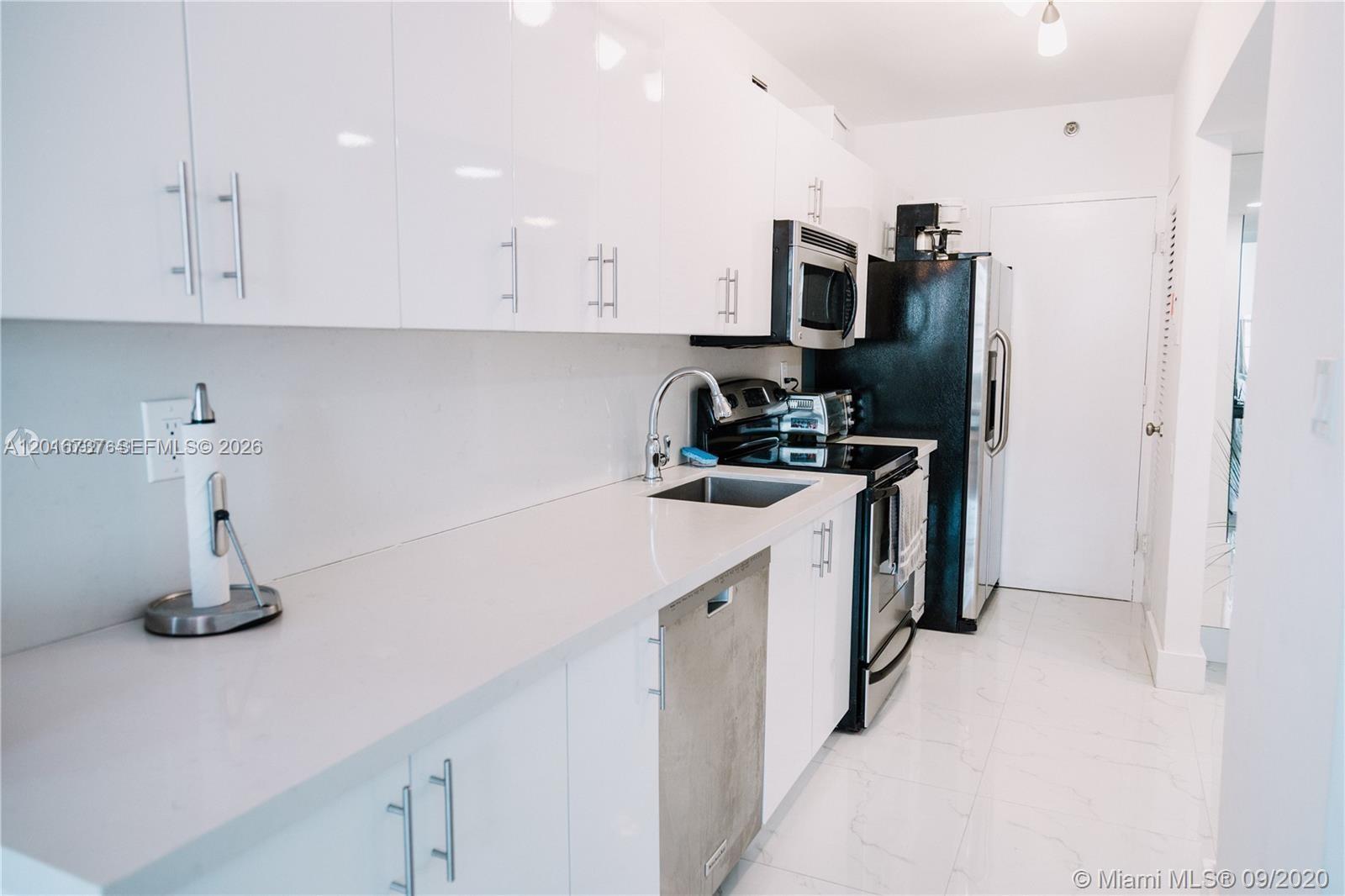 100 Lincoln Road, Unit 1526 Miami Beach, FL 33139 - Photo 4 of 9 a kitchen with a sink a stove and refrigerator