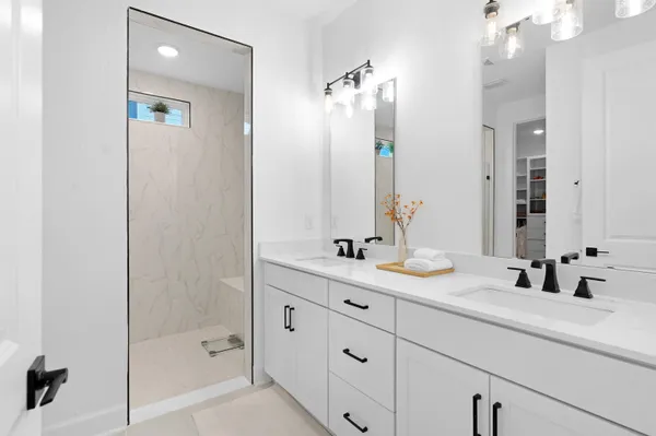 a bathroom with a sink a toilet a mirror a bathtub and shower