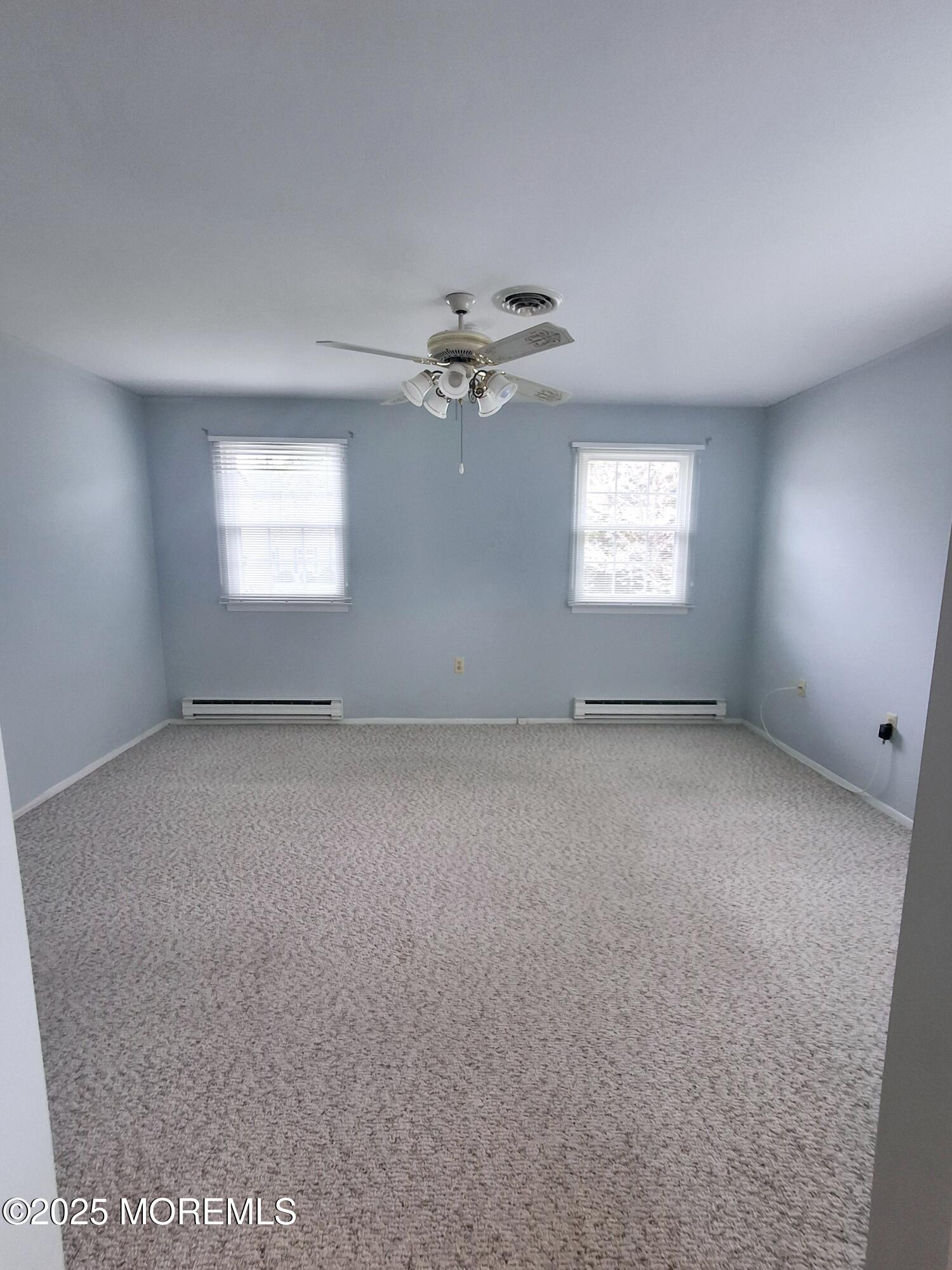 92 Sunset Road, Unit 60 Whiting, NJ 08759 - Photo 12 of 25 an empty room with windows and ceiling fan