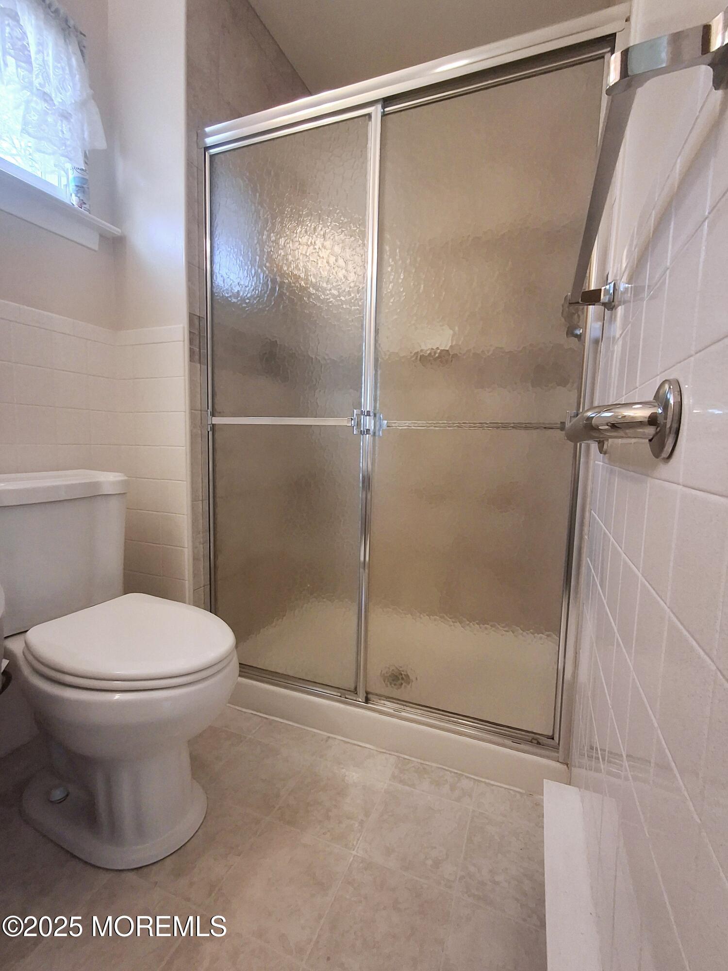 92 Sunset Road, Unit 60 Whiting, NJ 08759 - Photo 16 of 25 a bathroom with a shower and a toilet