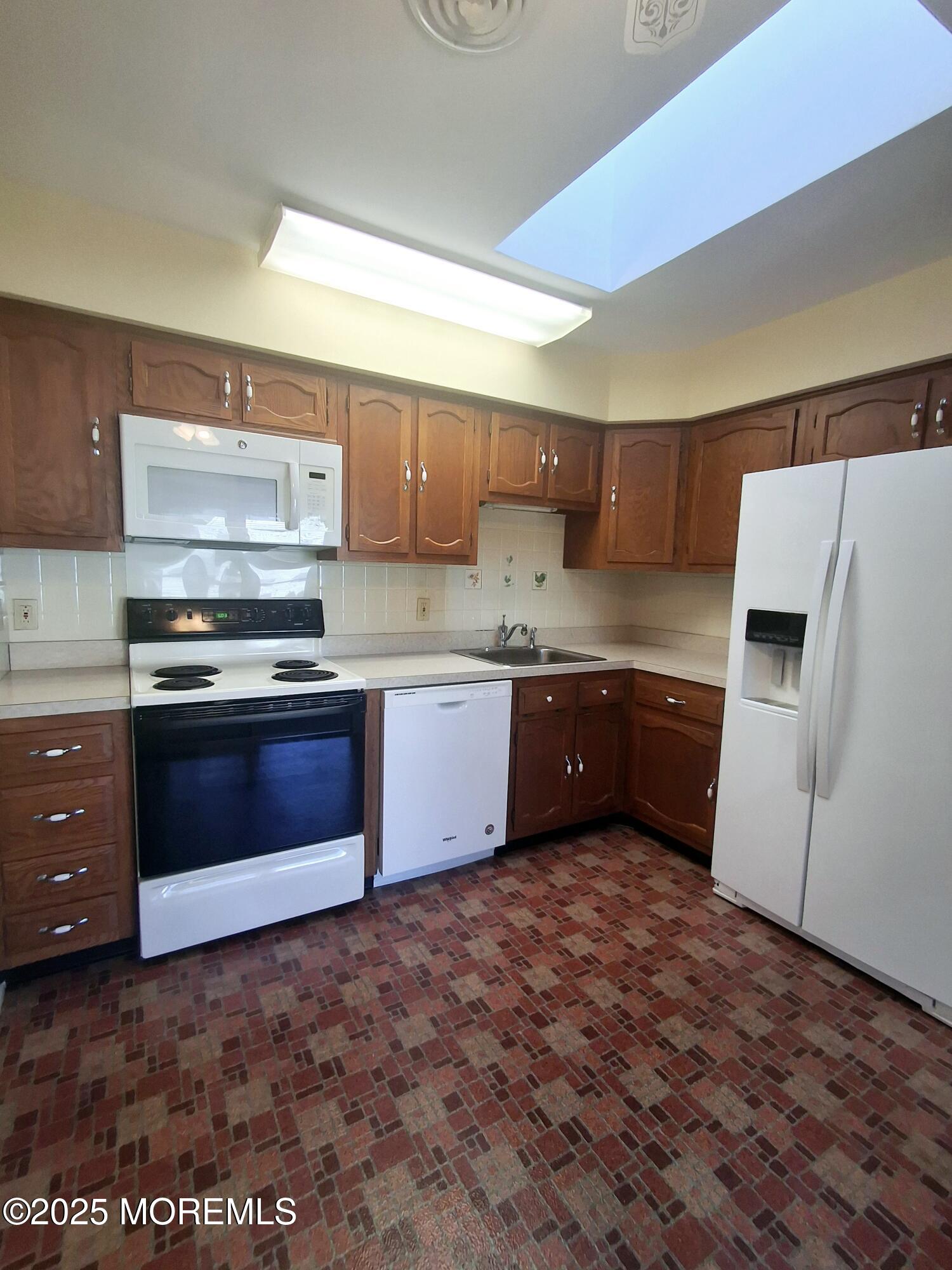 92 Sunset Road, Unit 60 Whiting, NJ 08759 - Photo 21 of 25 a kitchen with stainless steel appliances a stove a sink and a refrigerator