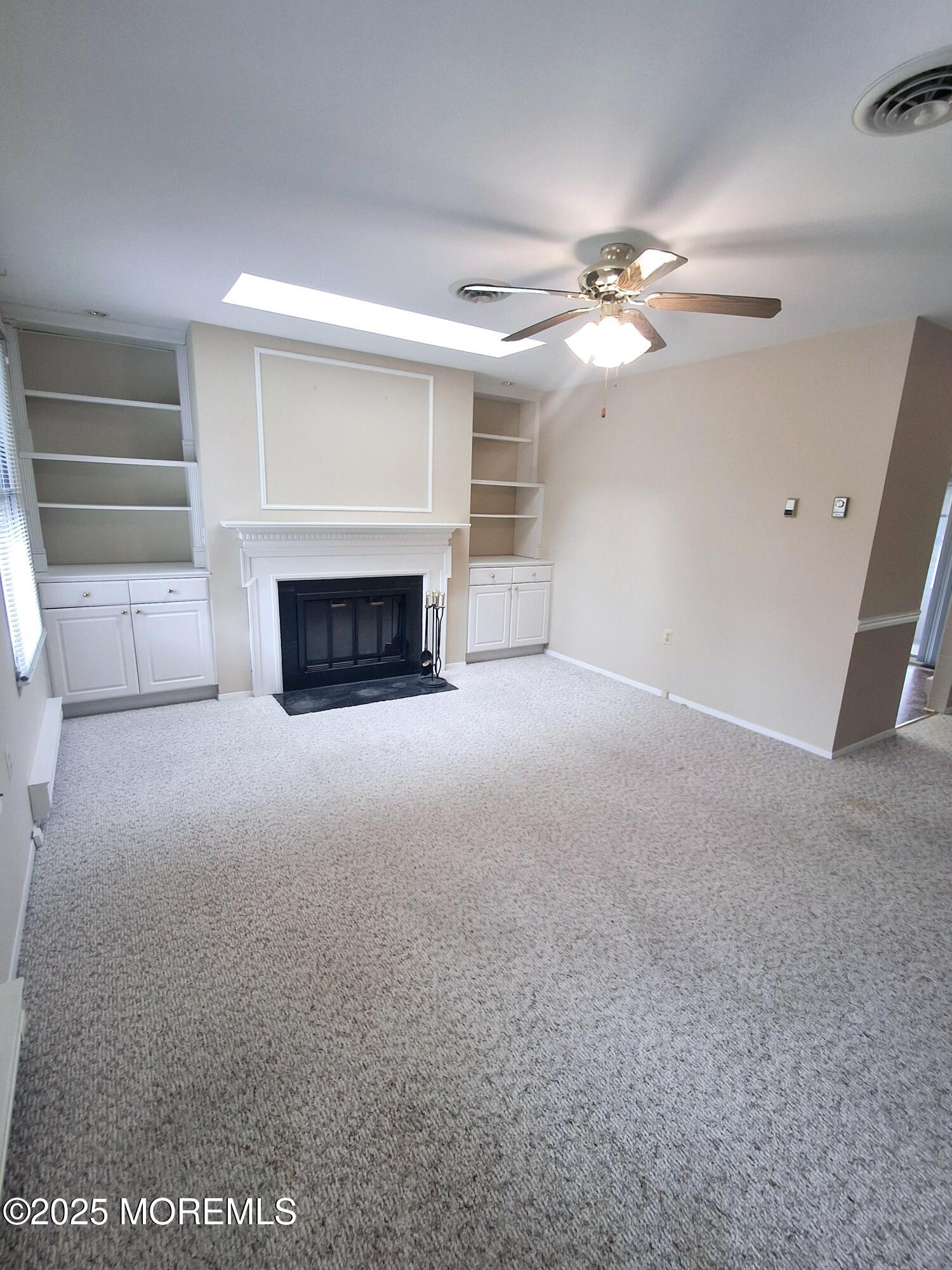 92 Sunset Road, Unit 60 Whiting, NJ 08759 - Photo 6 of 25 a view of a livingroom with a fireplace and a ceiling fan