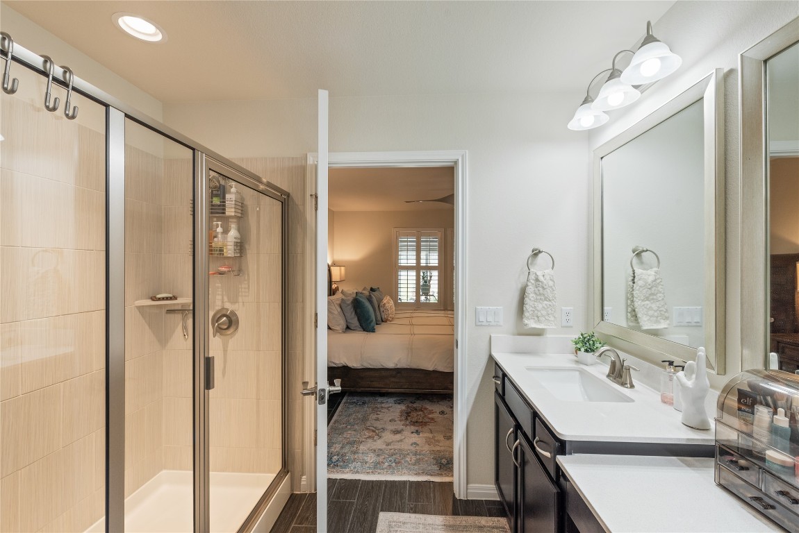 307 Hobby Street Georgetown, TX 78633 - Photo 23 of 40 a en suite bathroom with a double vanity sink a mirror and shower