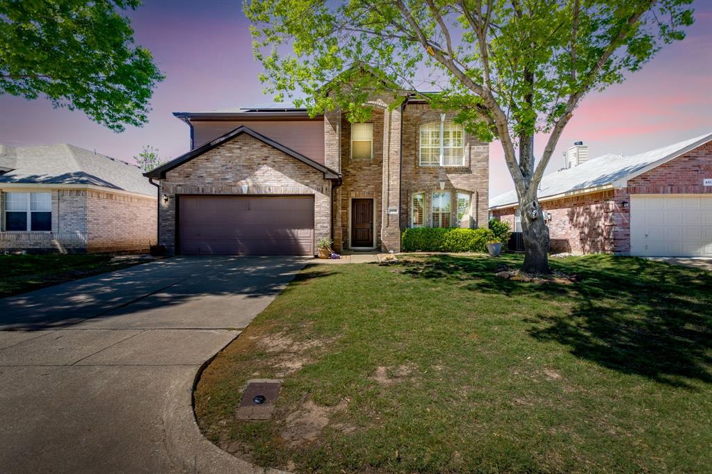 4816 Sleepy Ridge Circle Fort Worth, TX 76133 - Photo 1 of 36 *Digitally Enhanced Twilight* Traditional-style house featuring roof mounted solar panels, driveway, an attached garage, and a front yard