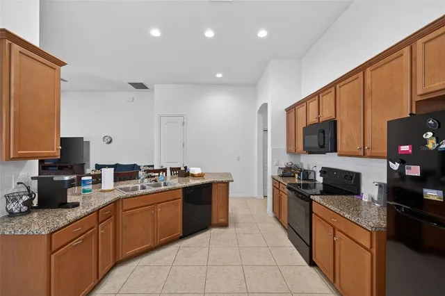 a kitchen with stainless steel appliances granite countertop a sink counter space cabinets and a large window