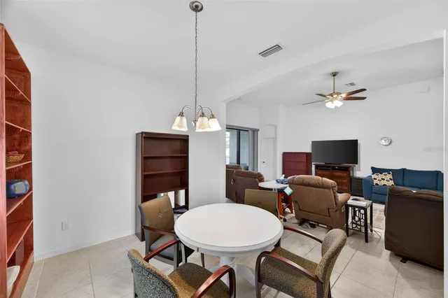 a living room with furniture a ceiling fan a fireplace and a window