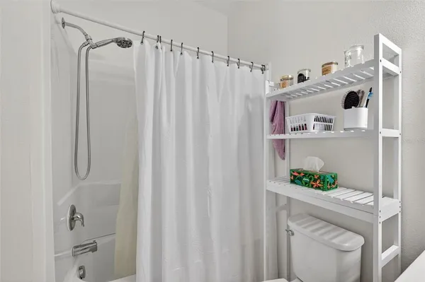 a bedroom with a bed and a dresser next to a window