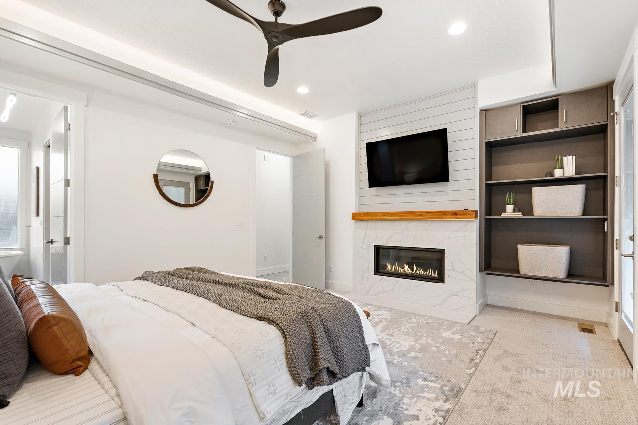 599 West Warren Street Boise, ID 83706 - Photo 18 of 41 Contemporary bedroom featuring a linear fireplace with a marble-look surround and wood mantel