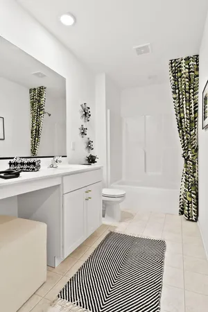 a spacious bathroom with a double vanity sink a toilet and a mirror