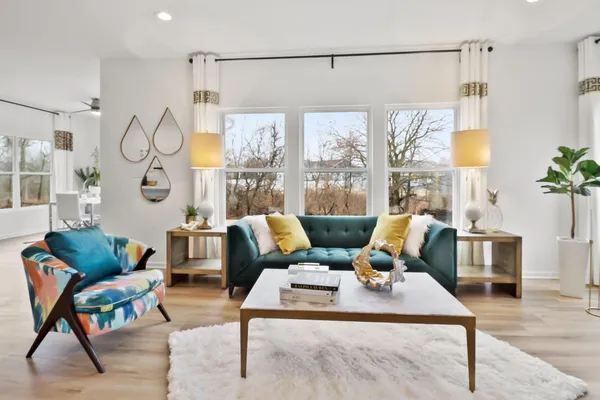 a living room with furniture a rug and a large window