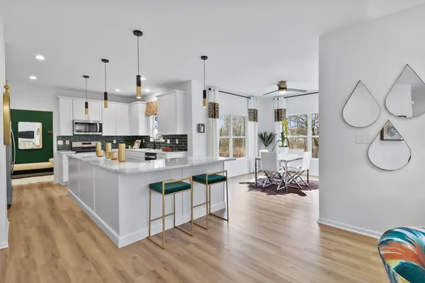 a large white kitchen with lots of counter space and stainless steel appliances
