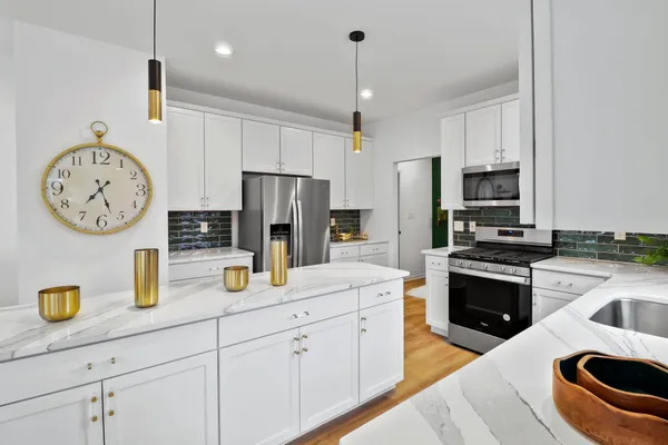 a kitchen with stainless steel appliances granite countertop a refrigerator a stove and a sink