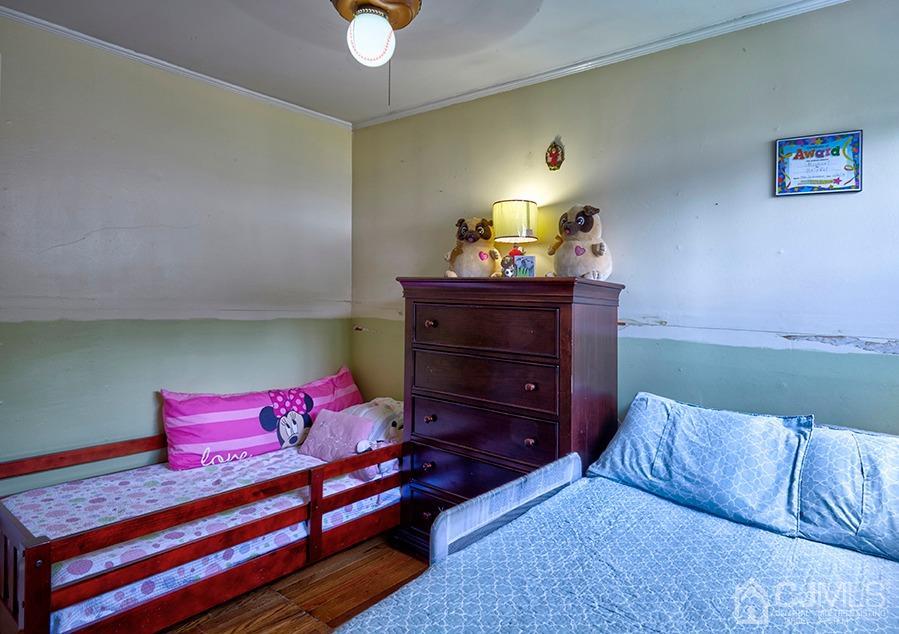 10 Pennington Road New Brunswick, NJ 08901 - Photo 17 of 29 a bed room with a bed and a lamp on dresser