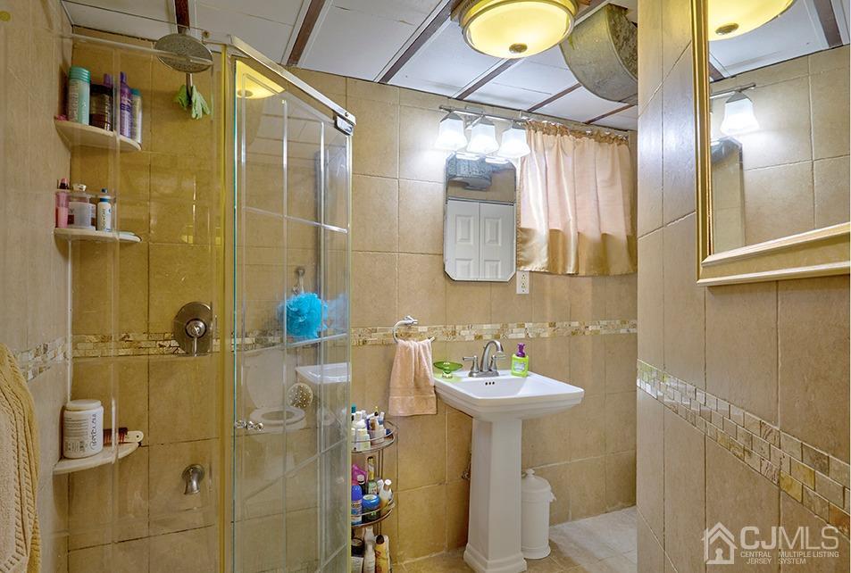 10 Pennington Road New Brunswick, NJ 08901 - Photo 19 of 29 a bathroom with a sink mirror and shower