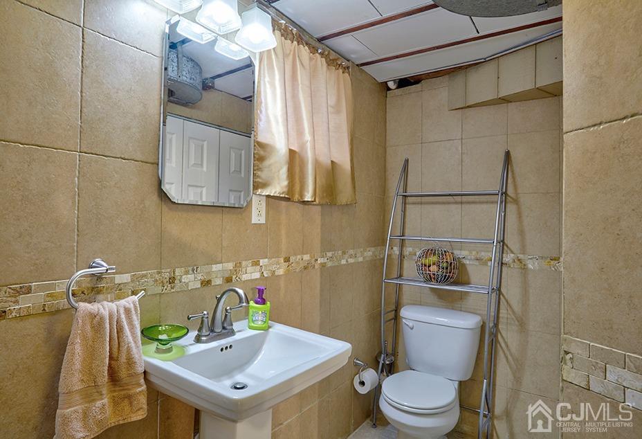 10 Pennington Road New Brunswick, NJ 08901 - Photo 20 of 29 a bathroom with a sink a toilet and a mirror