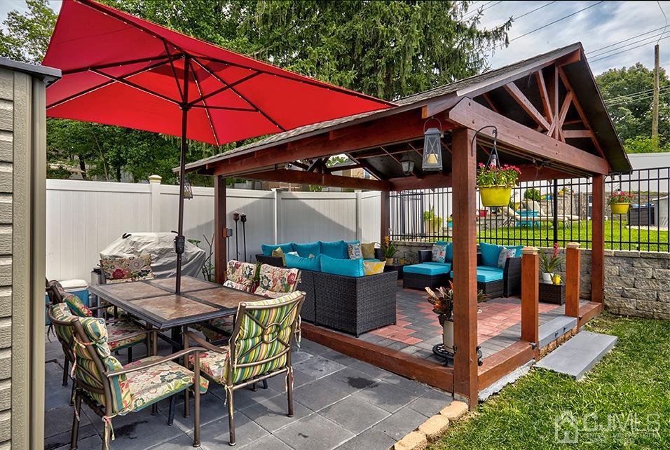 10 Pennington Road New Brunswick, NJ 08901 - Photo 25 of 29 a patio with a table and chairs under an umbrella