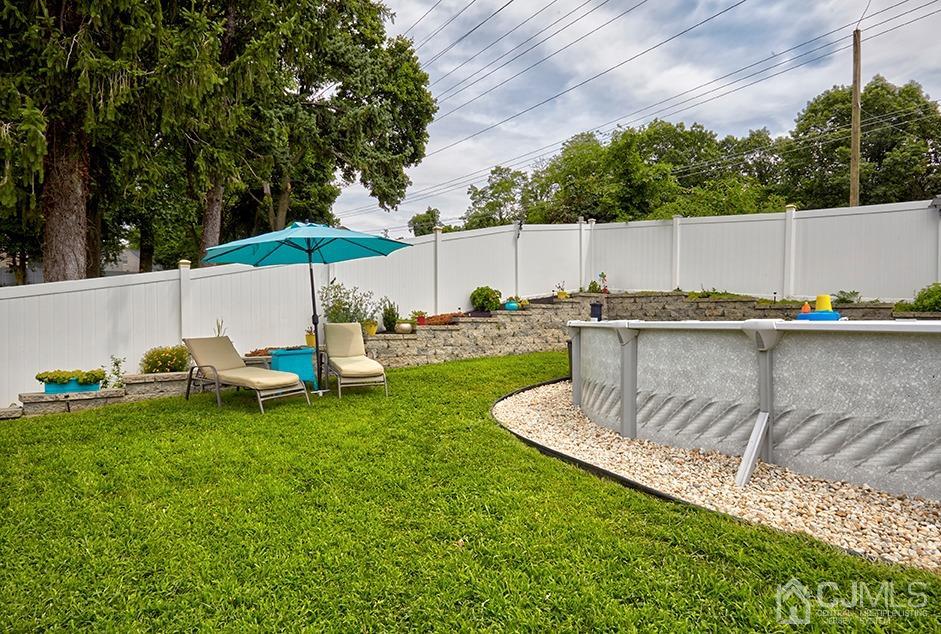 10 Pennington Road New Brunswick, NJ 08901 - Photo 27 of 29 a backyard of a house with table and chairs under an umbrella