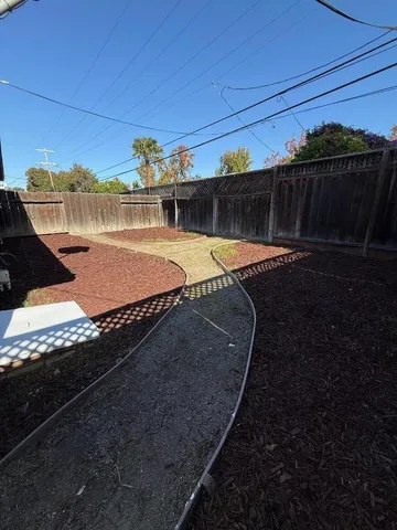 a view of a backyard with wooden fence