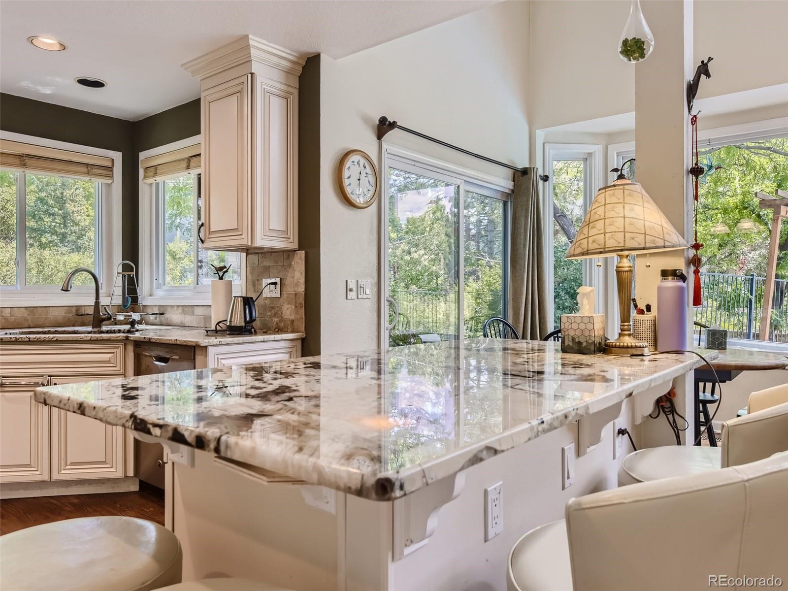 6722 Eagle Place Highlands Ranch, CO 80130 - Photo 6 of 34 a room with kitchen island a large window cabinets a sink and stainless steel appliances