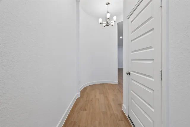 a view of a hallway with wooden floor and closet