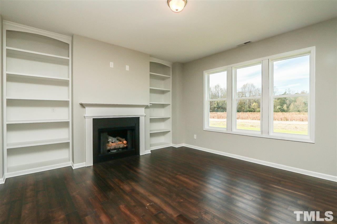 285 Bella Square Smithfield, NC 27577 - Photo 3 of 30 a view of an empty room with a fireplace and a window