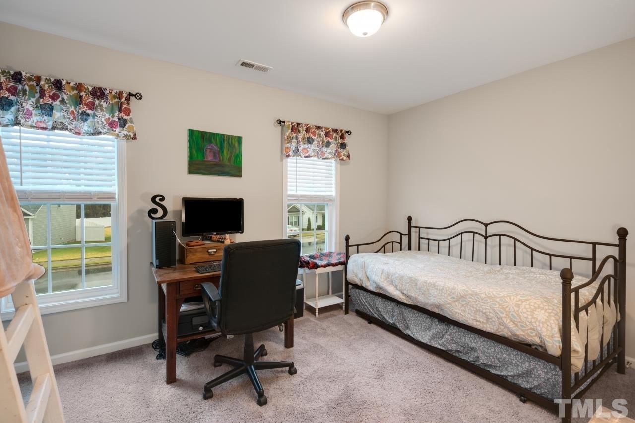 285 Bella Square Smithfield, NC 27577 - Photo 22 of 30 a bedroom with a bed a computer on the desk and a chair