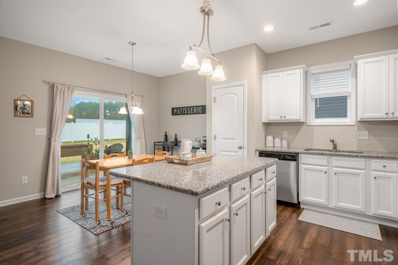 285 Bella Square Smithfield, NC 27577 - Photo 5 of 30 a kitchen with stainless steel appliances granite countertop a stove top oven a sink dishwasher and white cabinets with wooden floor