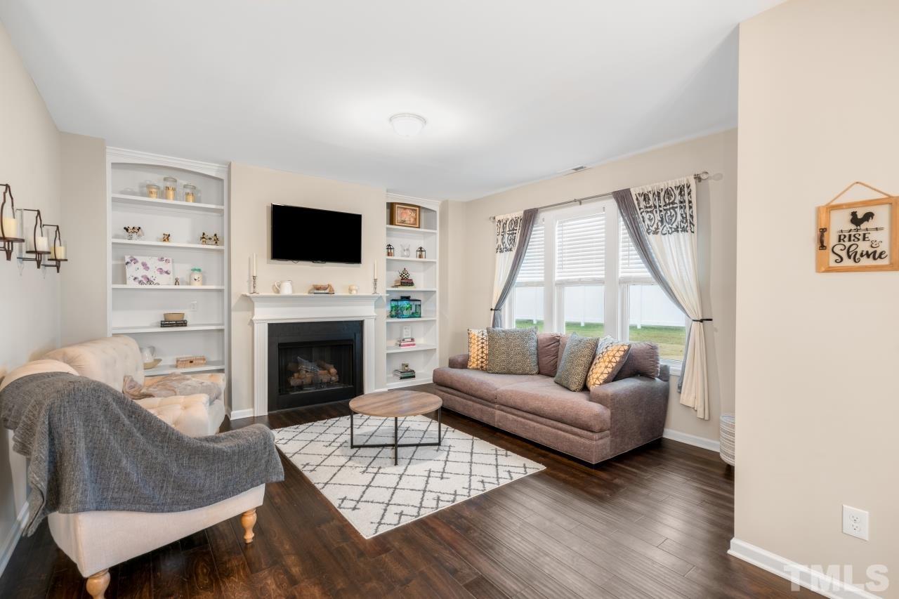 285 Bella Square Smithfield, NC 27577 - Photo 7 of 30 a living room with furniture a flat screen tv and a fireplace