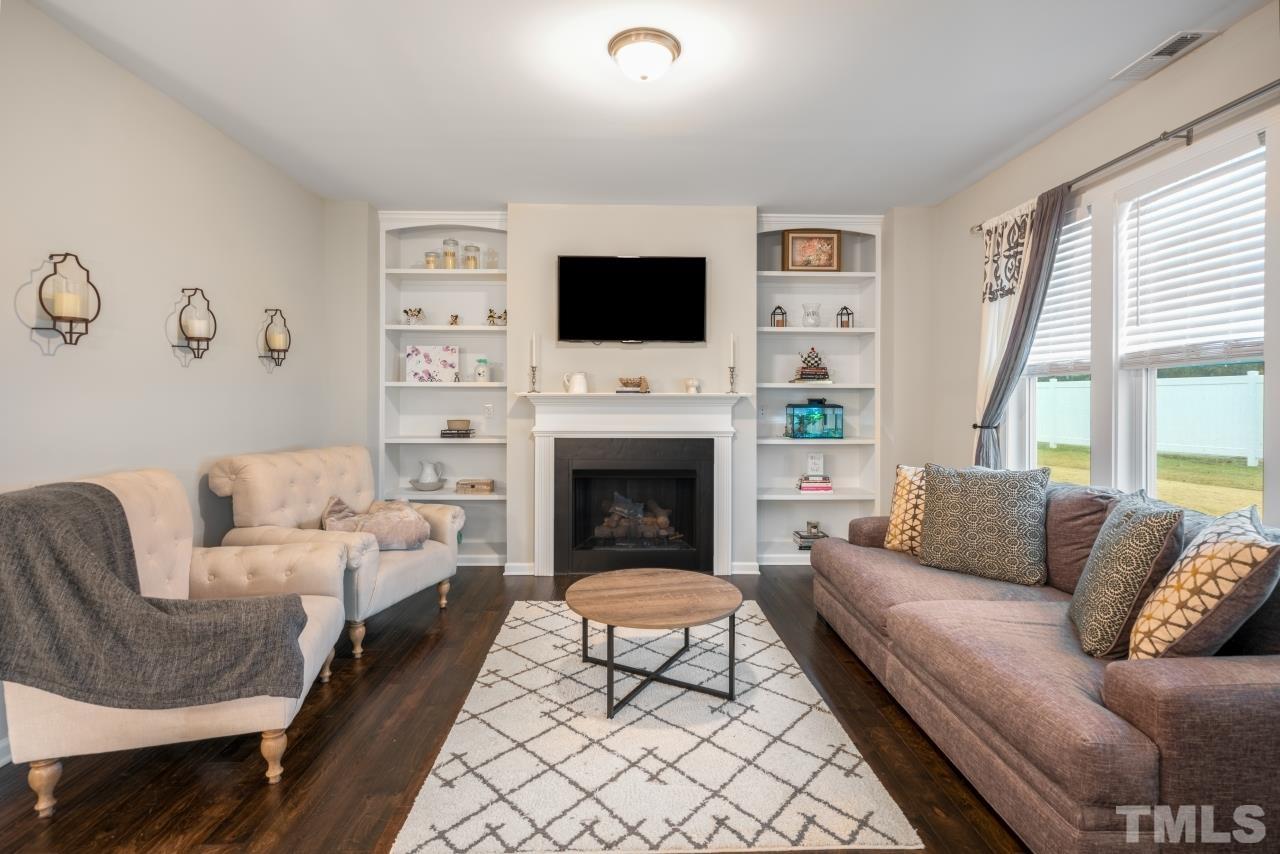 285 Bella Square Smithfield, NC 27577 - Photo 8 of 30 a living room with furniture a flat screen tv and a fireplace