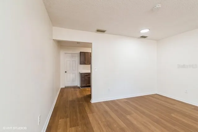 a view of a room with wooden floor and a ceiling fan
