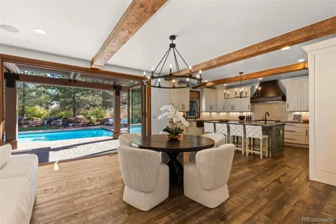 a dining room with furniture a floor to ceiling window and wooden floor